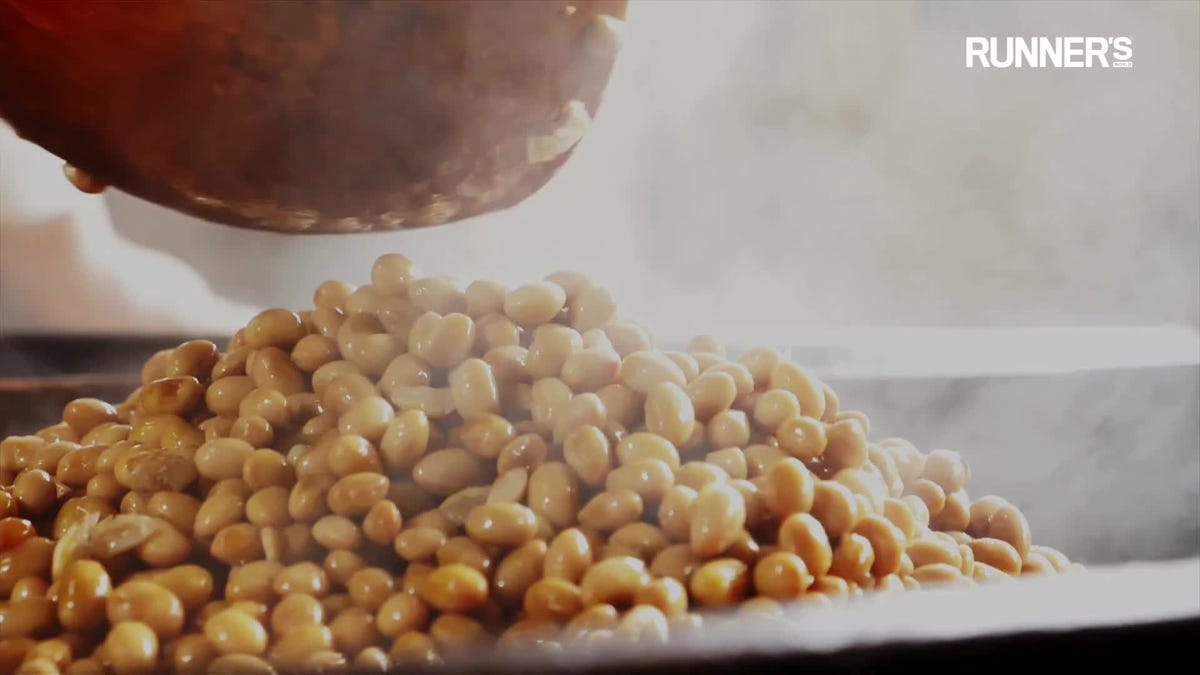 hands of an anonymous woman hlding cooked garbanzo beans in a bowl