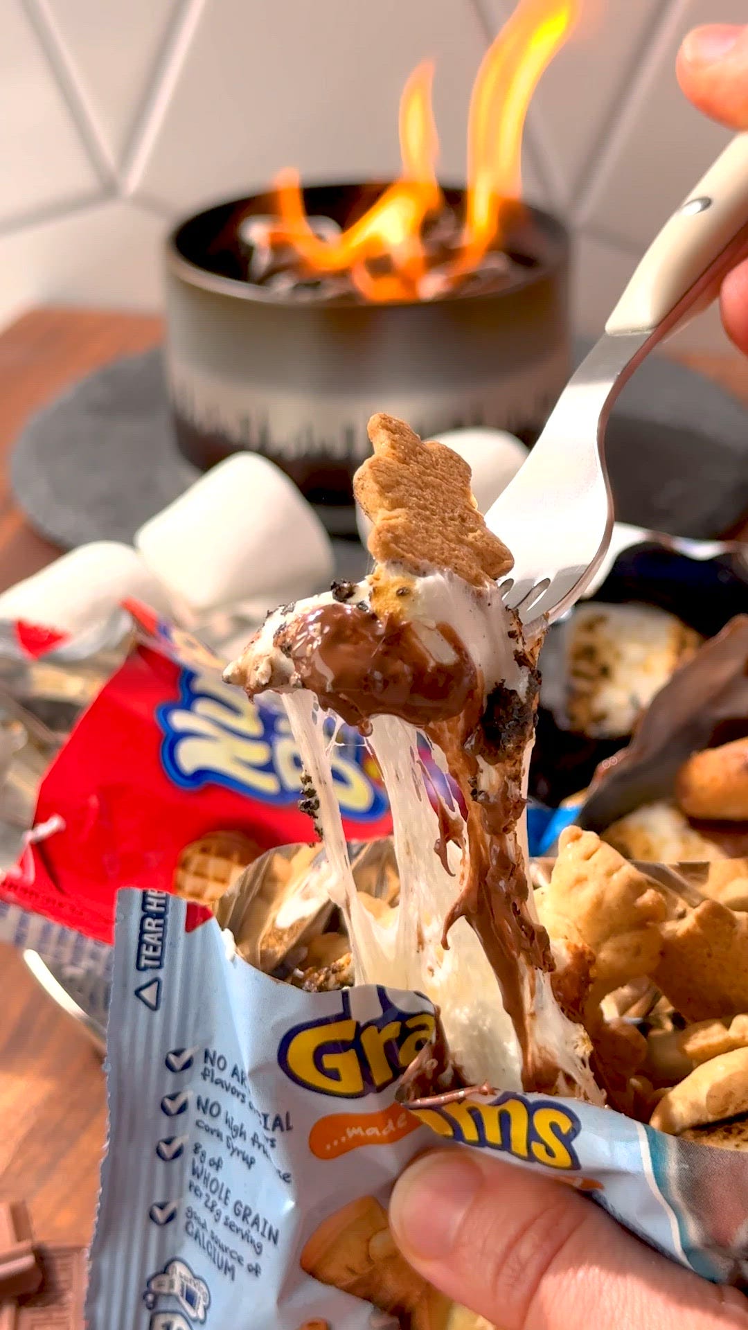 bags of oreos, chocolate chip cookies, and teddy grahams filled with toasted marshmallows and chocolate