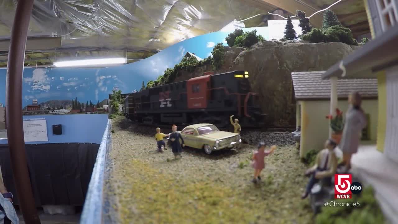 An elaborate scale model railroad layout chugs its engine in a