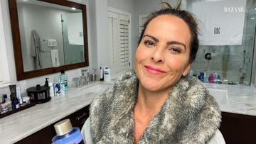 kate del castillo stands in her nice bathroom holding a beauty product