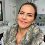 kate del castillo stands in her nice bathroom holding a beauty product
