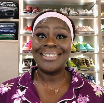 retta smiles into the camera from inside her big walking closet