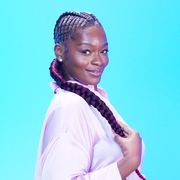 a young black woman shows off her pineapple knot braids