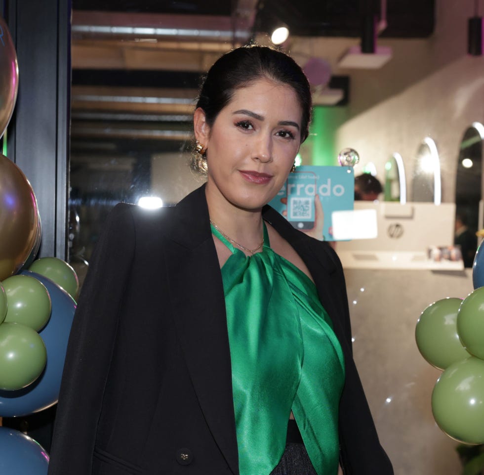 la empresaria con top verde y americana negra