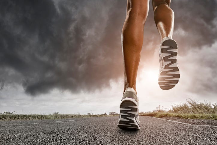 man running up a rocky hill