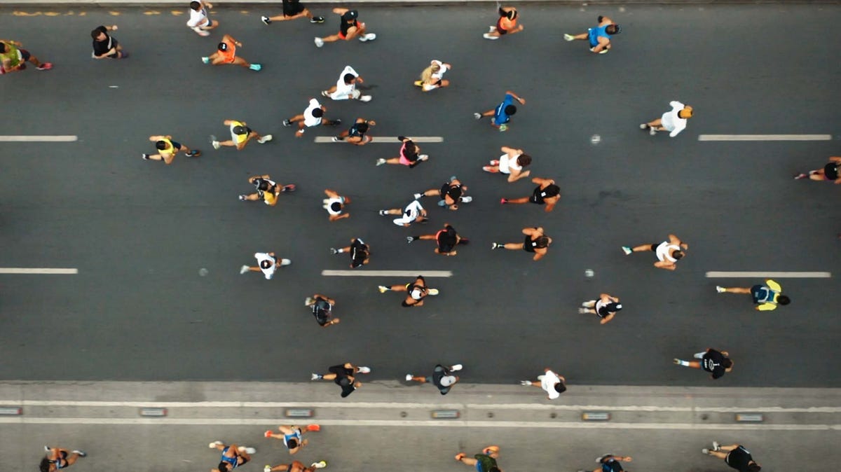 runner speeding down a paved path with new york city in the background