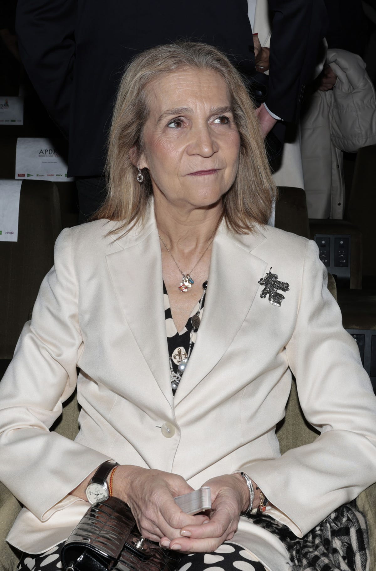 la infanta elena con el pelo liso y una blazer en color blanco sobre un mono de lunares