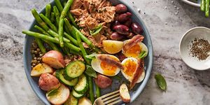 niçoise salad with tuna, jammy eggs, anchovies, green beans, potatoes, cucumbers, olives and capers