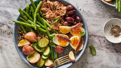 niçoise salad with tuna, jammy eggs, anchovies, green beans, potatoes, cucumbers, olives and capers