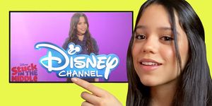 jenna ortega smiling and pointing to her image drawing the disney channel logo