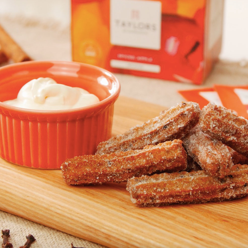 aldi churro maker with churros and a strawberry sauce