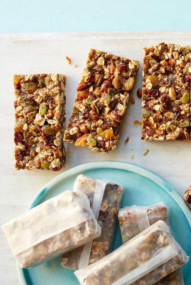 wrapped fruit and nut bars on blue plate and wooden surface