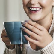 woman smiling and drinking a cup of tea