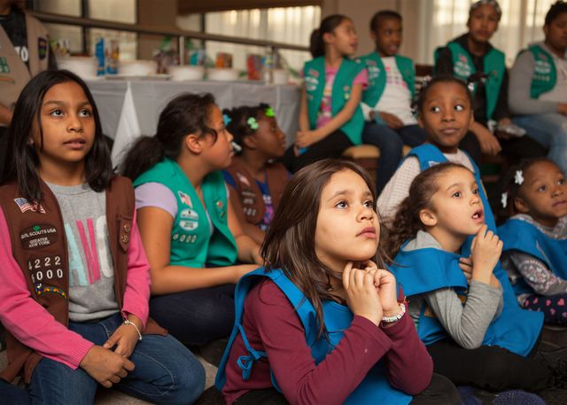 Girl scout troop listens at a meeting.