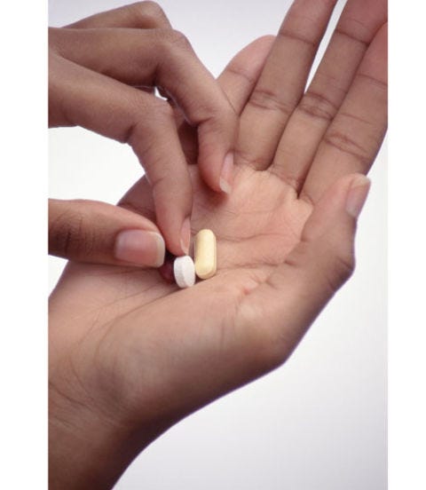 Sleep Stealer: Your to-do list is running through your head. woman holding vitamins in her hand
